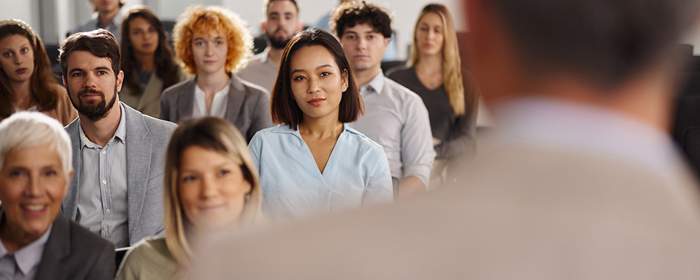 Imagem com várias pessoas de diferentes lugares do mundo reunidas em um ambiente.