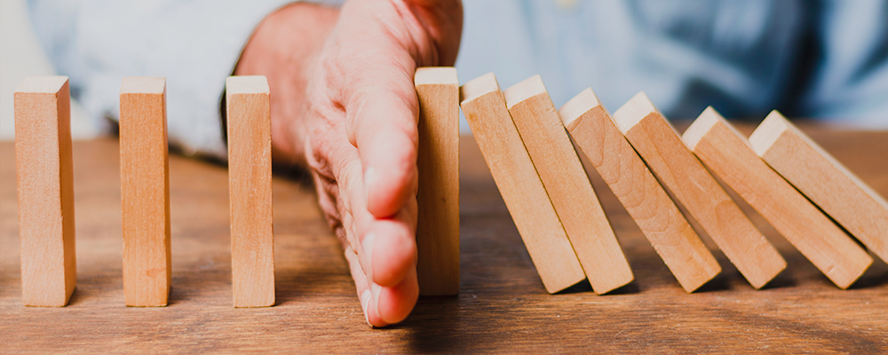 Imagem de uma mão segurando um efeito dominó