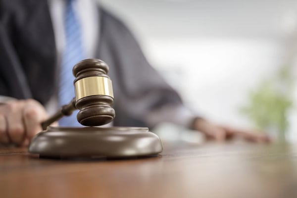 A imagem mostra um malhete, o martelo utilizado pelos juízes em tribunais.