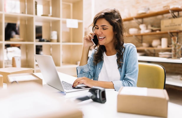 Mulher atendendo telefone em um ambiente de trabalho, provavelmente uma loja de artigos domésticos