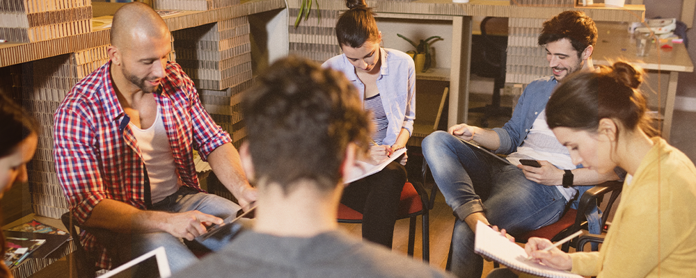 Imagem de uma roda de conversa numa empresa, com um profissional do RH mediando a conversa.