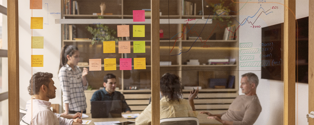 Imagem de pessoas em uma sala de reuniões discutindo um projeto