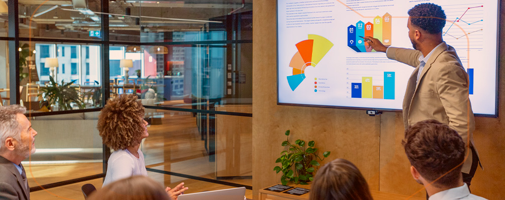 Uma equipe em reunião apresentando dados sobre tecnologia e inovação